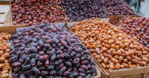 Different varieties of Iranian dates displayed in bulk at a traditional market, showcasing premium dates for wholesale trade.